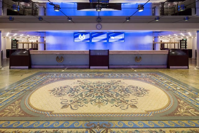 Elegant event space at Oper Frankfurt with tiled floor and blue lighting. Perfect for meetings.