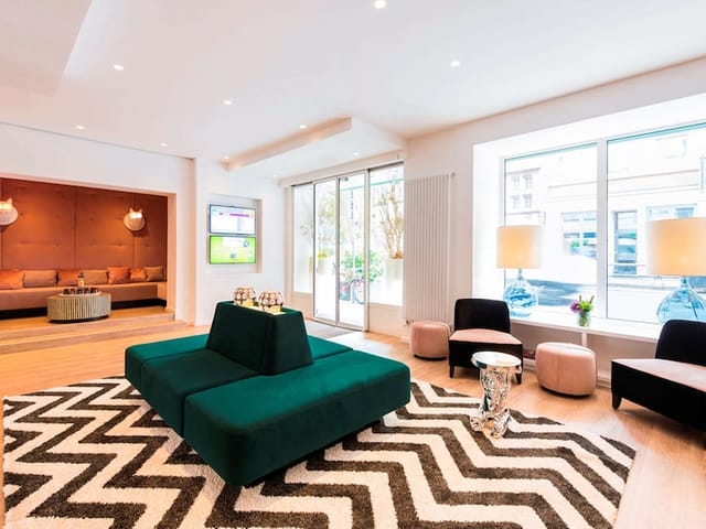 Modern event space in ibis Styles Frankfurt with vibrant green seating, ideal for conferences.