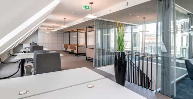 Modern open office in Frankfurt, featuring minimalist furniture for collaboration and productivity.