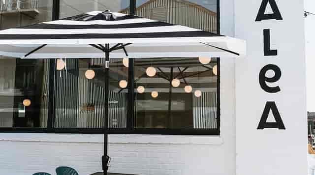 Outdoor event space at TALEA Beer Co. with striped umbrella, ideal for gatherings.