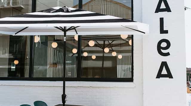 Outdoor event space at TALEA Beer Co. with striped umbrella, ideal for gatherings.