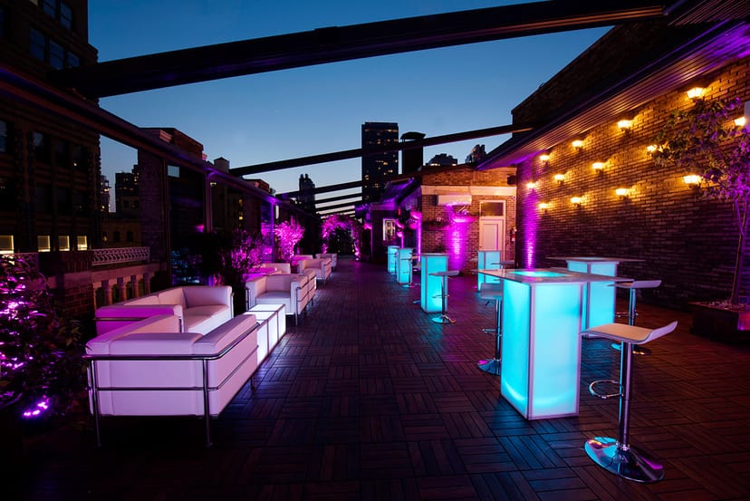 Stylish rooftop event space with vibrant purple lighting for upscale gatherings.