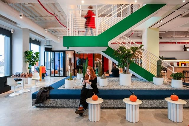 Modern meeting space with green staircase, perfect for networking and collaboration.