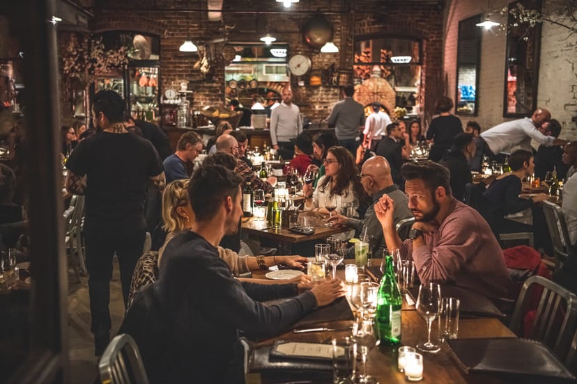 Vibrant Peasant restaurant bar with communal tables, ideal for social events and gatherings.