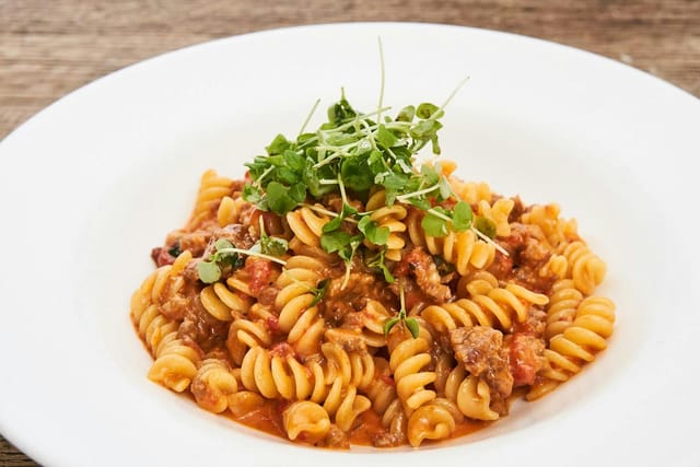 Private event room pasta dish with fusilli in meat sauce - catering, meetings.