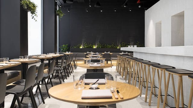 Modern dining space in ATLA NOHO for events with sleek round tables and minimalist decor.