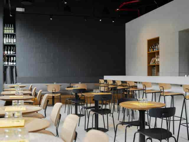 Modern event space in ATLA NOHO with rounded wooden tables, ideal for receptions and networking.