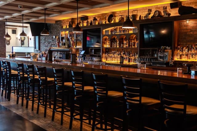 Modern bar with warm lighting, ideal for networking events and casual gatherings.