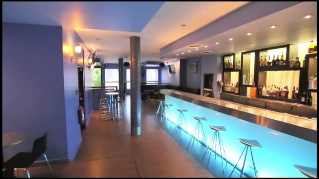 Modern bar in Ascent Lounge with vibrant blue walls for networking events.