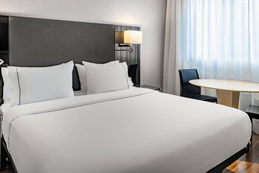Modern hotel room with king-sized bed at AC Hotel Madrid Feria for events and meetings.