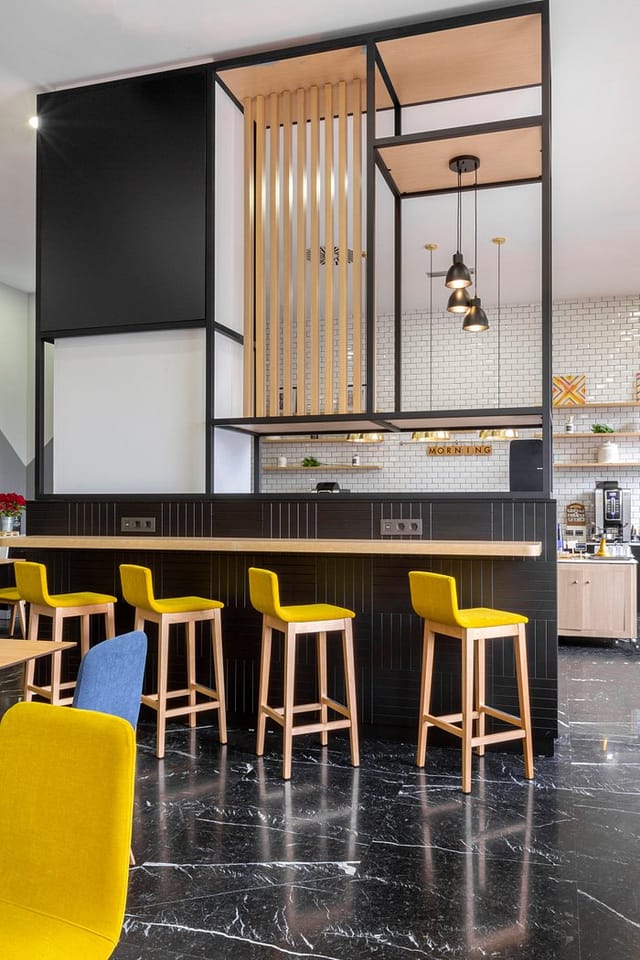Modern kitchen area in Holiday Inn Madrid for events, featuring sleek bar counter and vibrant seating.