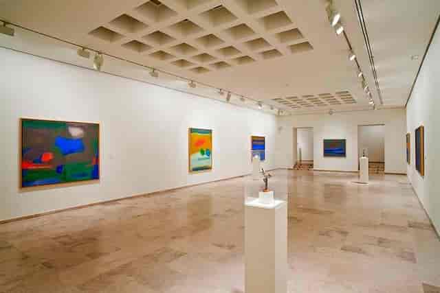 Spacious art gallery with abstract works, perfect for upscale events and receptions.