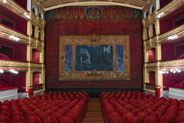 Elegant red-themed auditorium in Teatro Calderón, perfect for conferences and cultural events.