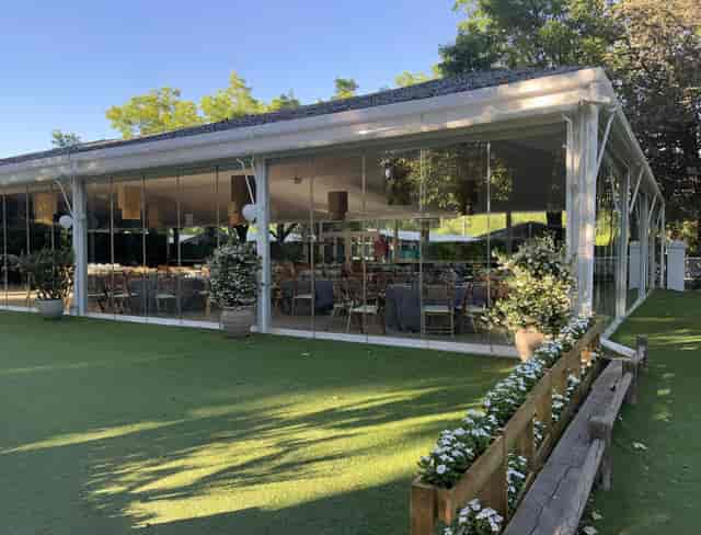 Modern glass-enclosed venue at Club de Campo Villa de Madrid for events and gatherings.