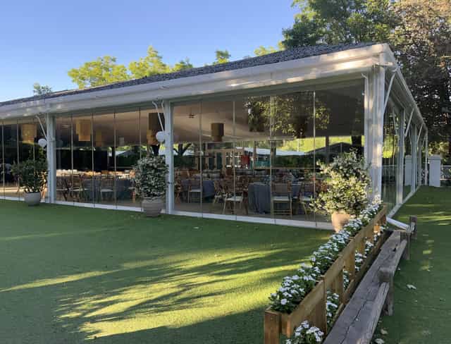Modern glass-enclosed venue at Club de Campo Villa de Madrid for events and gatherings.
