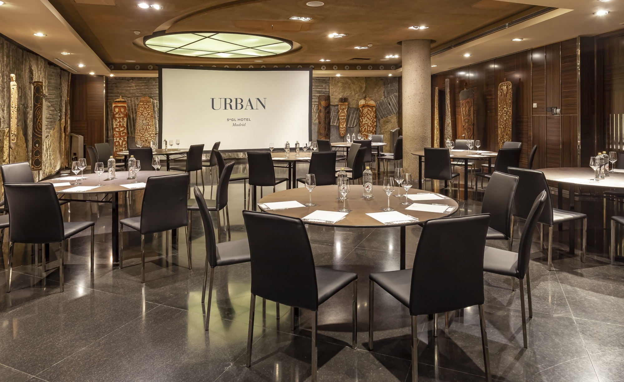 Modern conference room at Hotel Urban with circular tables and ambient lighting.