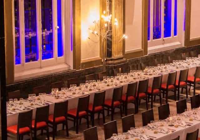 Elegant product launch dinner setup in Spathios Madrid with stylish red seating.