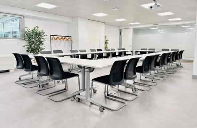 Modern training classroom in Ibercenter for corporate events, featuring a long table and sleek chairs.