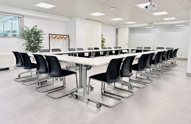 Modern training classroom in Ibercenter for corporate events, featuring a long table and sleek chairs.