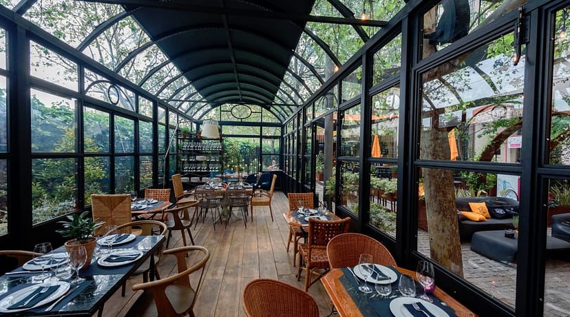 Elegant glass-enclosed venue with greenery for upscale events and intimate gatherings.