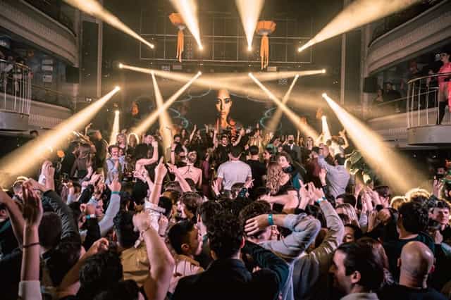 Energetic nightclub event at Teatro Kapital with dramatic lighting and vibrant crowd.