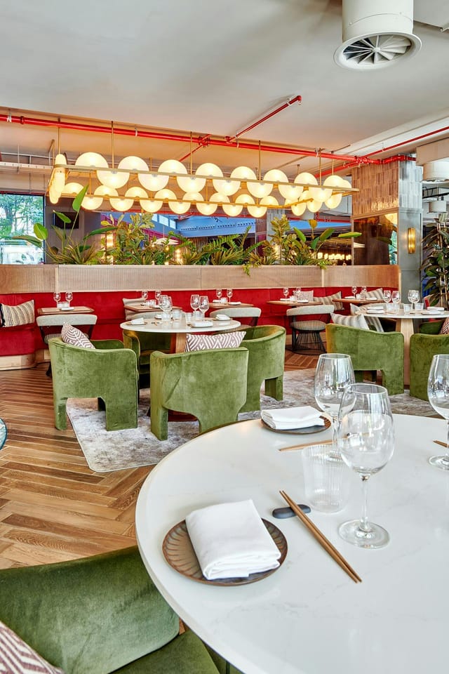 Stylish dining area in Radisson RED Madrid with modern green chairs for upscale events.