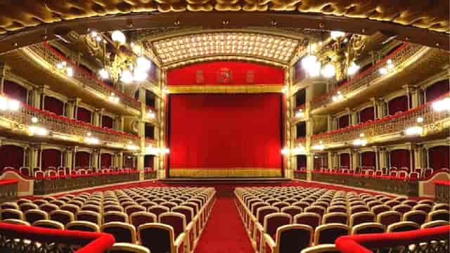 Elegant theater stage with red curtain, ideal for performances and corporate events.