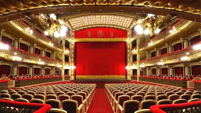 Elegant theater stage with red curtain, ideal for performances and corporate events.