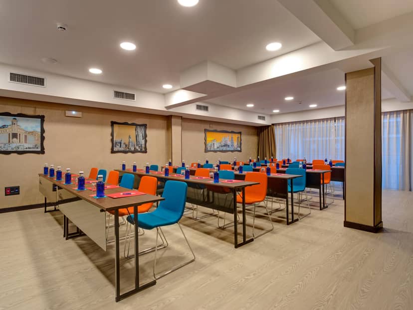 Modern conference room with vibrant chairs at Hotel Indigo Madrid Gran Vía for workshops.