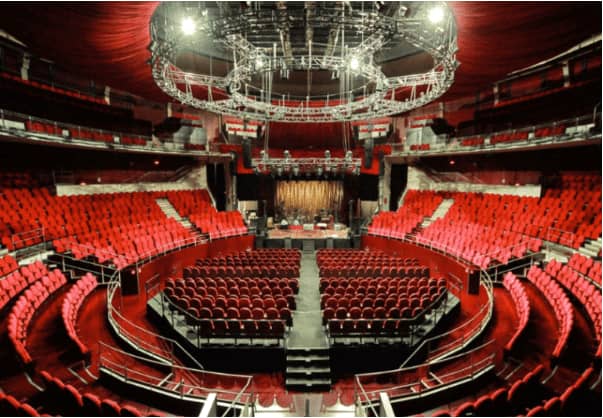 Vibrant Teatro Circo Price auditorium with tiered red seating, perfect for events.