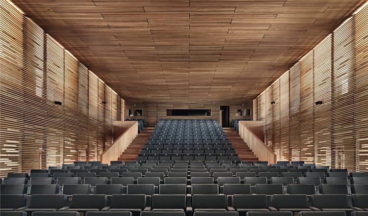 Sleek modern auditorium with tiered seating for conferences and presentations.