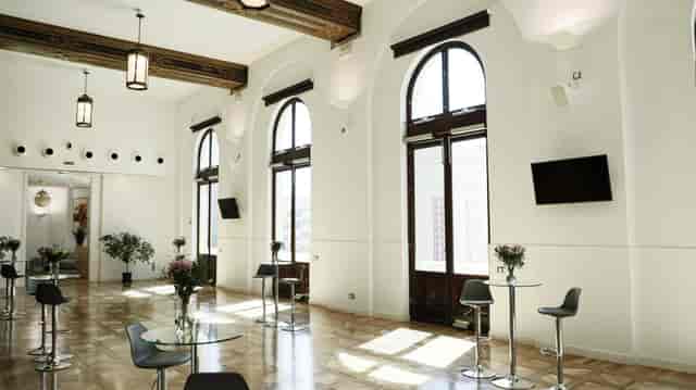 Spacious Trocadero venue with arched windows, ideal for corporate events and gatherings.