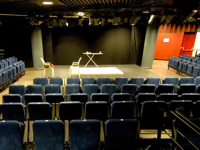 Alt tag: Auditorium at Nuevo Teatro Alcalá with blue chairs, ideal for events and workshops.