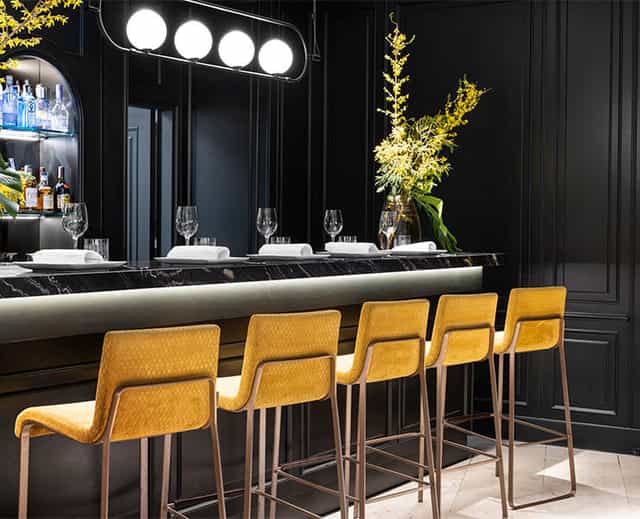 "Sala Club at Hotel Emperador: Modern bar with yellow chairs, ideal for cocktail receptions."