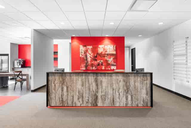 Modern reception area at 28 Valley Road with red walls, perfect for events and meetings.