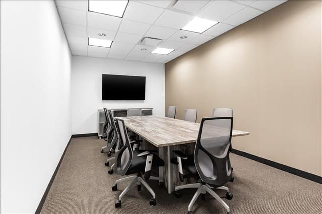 Modern conference room with wooden table, ideal for corporate meetings and workshops.
