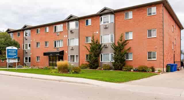 Oakville Manor: multi-story brick lodging near event venues with lush landscaping.
