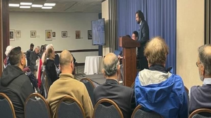 Small audience at National Press Club conference with speaker at podium, engaging meeting.