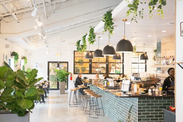 Modern café at Isla & Co. with greenery, perfect for informal meetings and events.