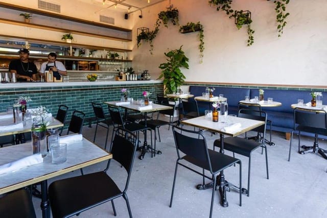 Modern dining room at Isla & Co., featuring greenery, perfect for workshops and events.