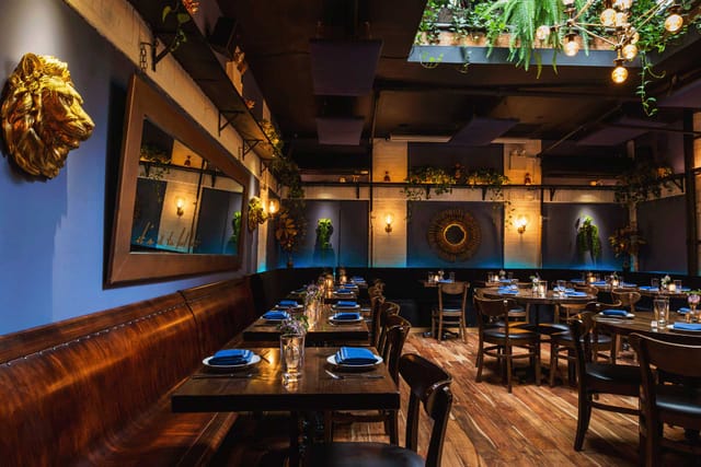 Stylish restaurant interior in Alice NYC with lion head wall art, ideal for events.