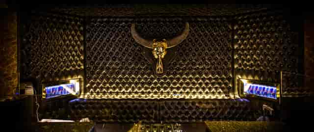 Upscale bar in Heist with black tufted wall, perfect for luxury events and gatherings.
