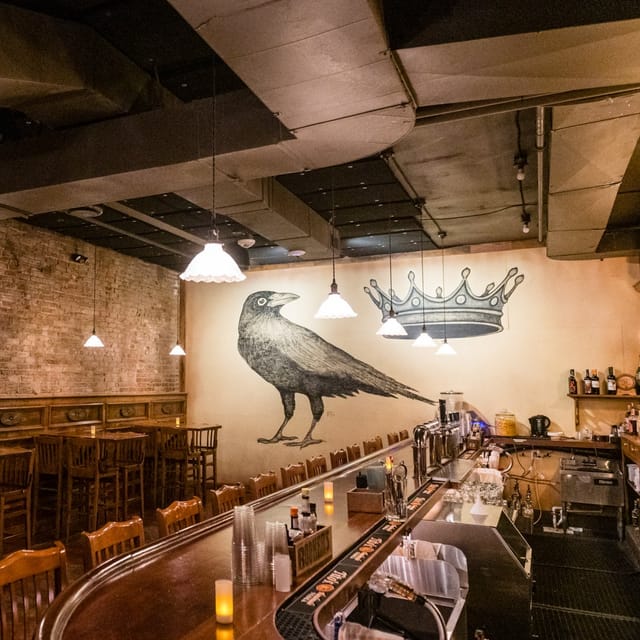Beer hall at The Crown & Crow with crow mural, perfect for gatherings and workshops.
