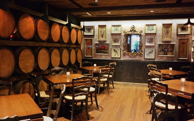 Rustic restaurant event space with wooden barrels, ideal for intimate gatherings or meetings.