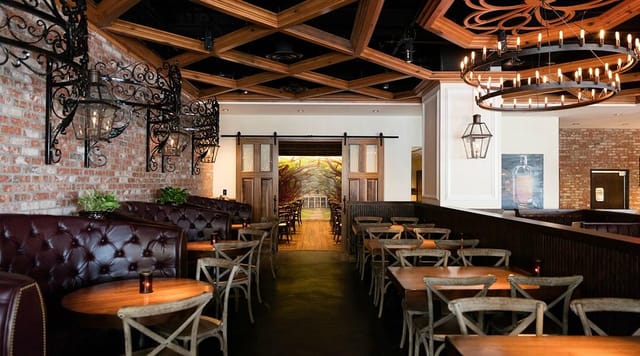 Elegant bar in Succotash, featuring a wooden ceiling for intimate meetings and events.