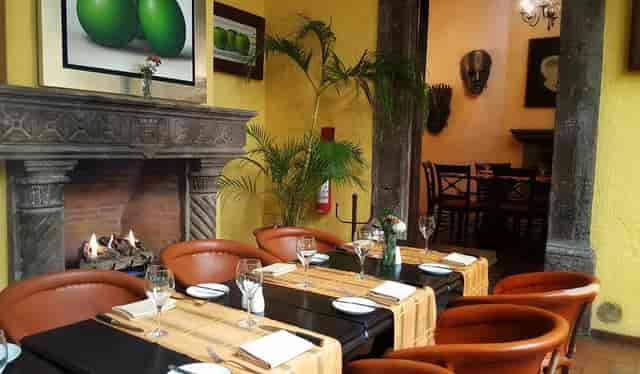 Elegant dining setup with fireplace at Mivida Restaurant for intimate events.