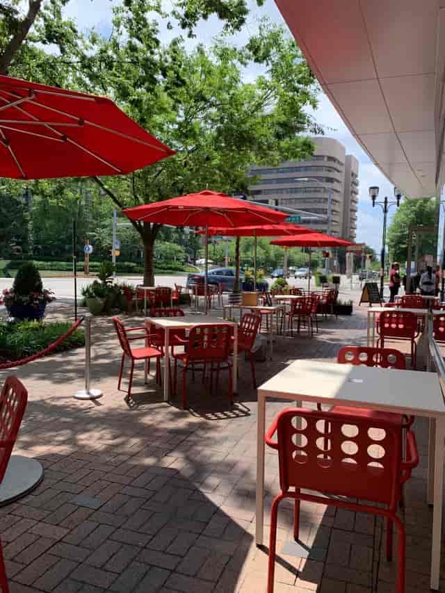 Vibrant outdoor dining at Jaleo with red umbrellas for casual networking events.