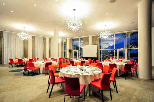 Modern banquet state room with round tables, ideal for corporate dinners and weddings.