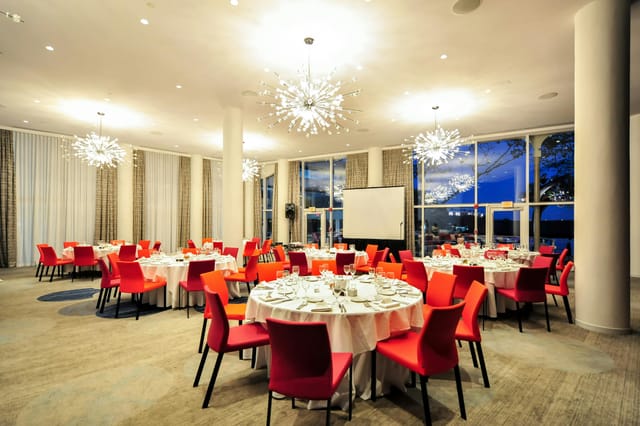 Modern banquet state room with round tables, ideal for corporate dinners and weddings.