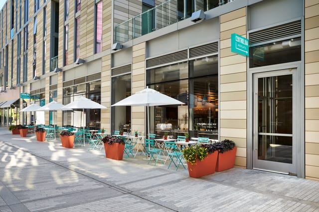 Modern outdoor seating at Osteria in Centrolina with turquoise tables for events.